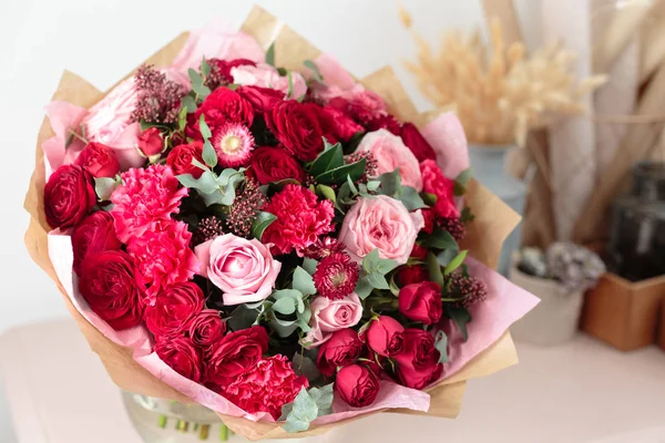 Primer plano hermoso ramo de lujo de flores rojas y rosadas mezcladas en jarrones de vidrio. el trabajo de la floristería en una florería. Fondos de pantalla — Foto de Stock