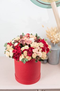 Güzel lüks kırmızı kutusunda karışık çiçekli buket. Çiçekçi Çiçek dükkanında çalışır. Duvar kağıdı