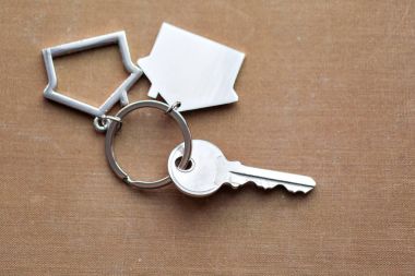 Evin anahtarı ve Anahtarlık evleri yalanlar üzerine kumaş şeklinde. Konsept Emlak, mortgage, ev taşıma veya mülkiyet Kiralama için.