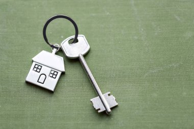 Evin anahtarı ve Anahtarlık evleri yalanlar üzerine kumaş şeklinde. Konsept Emlak, mortgage, ev taşıma veya mülkiyet Kiralama için.