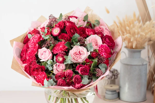 Primer plano hermoso ramo de lujo de flores rojas y rosadas mezcladas en jarrones de vidrio. el trabajo de la floristería en una florería. Fondos de pantalla — Foto de Stock