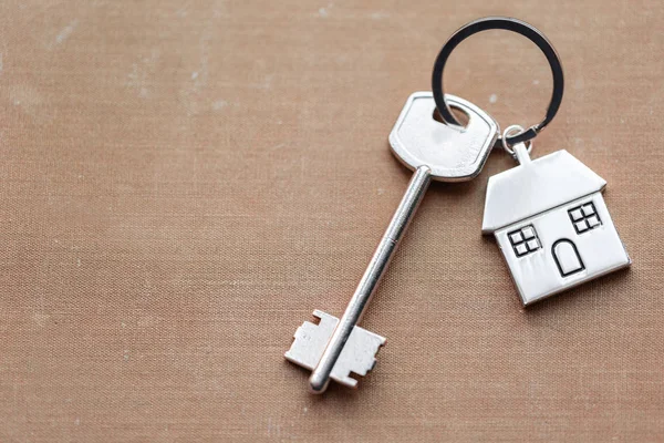 Evin anahtarı ve Anahtarlık evleri yalanlar üzerine kumaş şeklinde. Konsept Emlak, mortgage, ev taşıma veya mülkiyet Kiralama için.