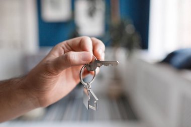 İpotek kavramı. Erkekler el ev tuşunu basılı tutarak Anahtarlık şeklinde. Modern ışık lobi iç. Ana sayfa taşıyarak veya Emlak Kiralama Emlak.