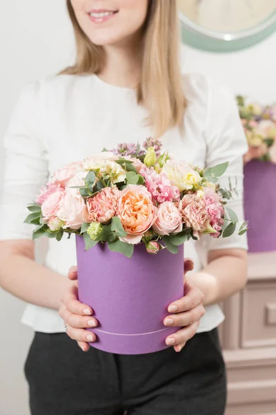 Enfoque selectivo en ramo en sombrerero lila. hermoso ramo de lujo de flores mixtas en la mano de las mujeres. el trabajo de la floristería en una florería. regalo o cumplido perfecto . — Foto de Stock