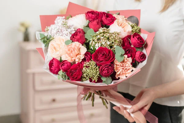 Ramo de color rojo intenso. hermoso ramo de lujo de flores mixtas en la mano de las mujeres. el trabajo de la floristería en una floristería . —  Fotos de Stock