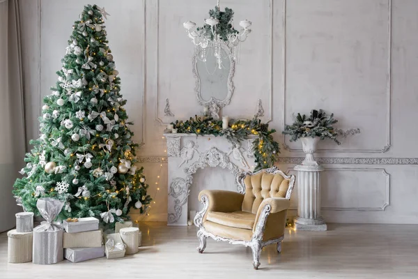 Mañana de Navidad. apartamentos clásicos con chimenea blanca, abeto decorado, sofá, grandes ventanales y lámpara de araña . — Foto de Stock