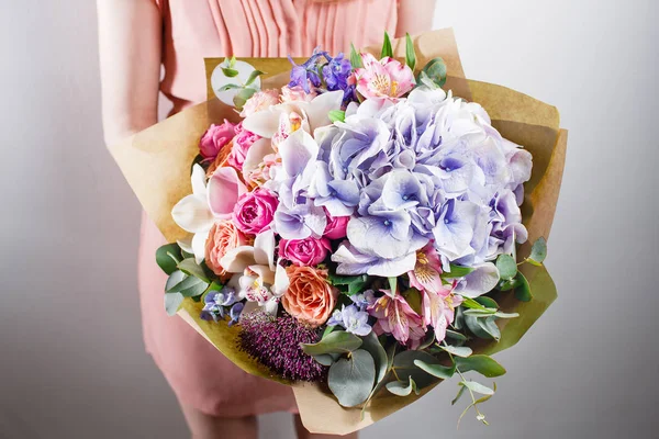 Mooie luxe boeket van gemengde bloemen in de hand van de vrouw. het werk van de bloemist op een bloemenwinkel — Stockfoto
