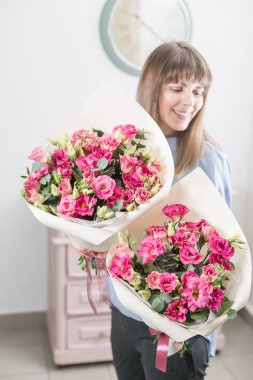 İki çiçek buketi. Güneşli bahar sabahı. Pembe eustoma veya Lisianthus güzel bir demet onun elinde tutan genç mutlu kadın. Gülümsüyor kız için hediye.