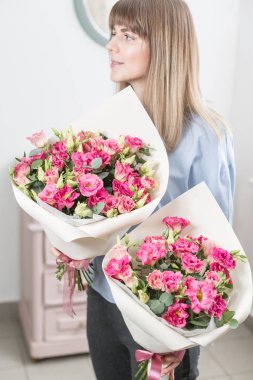 İki çiçek buketi. Güneşli bahar sabahı. Pembe eustoma veya Lisianthus güzel bir demet onun elinde tutan genç mutlu kadın. Gülümsüyor kız için hediye.