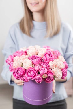 Menekşe headbox içinde çiçek buketi. Güzel bir buket pembe Gül tutan genç mutlu kadın. Gülümsüyor kız için hediye. Güneşli bahar sabahı.
