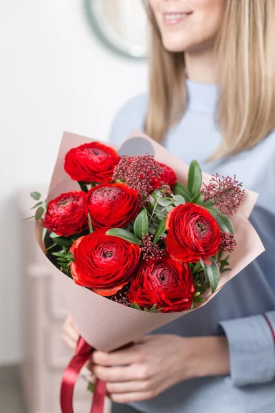 Sunny spring morning. Young happy woman holding a beautiful bunch of red buttercups or Ranunculus in her hands. Present for a smiles girl. Flowers bouquet — Stock Photo, Image