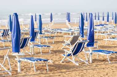 kumlu plaj Temizleme, kıştan sonra İtalya tatil sezonu için hazırlık. Deniz fırtınası sonra sahil üzerinde Tahta sandıklar içinde. yoğun deniz meltemi şafak