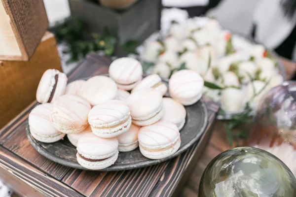 Pastelově růžové jahodový macarons. Francouzský delikátní dezert k snídani v ranním světle na dřevěný stůl. Malá hloubka ostrosti. Svatební hostinu — Stock fotografie