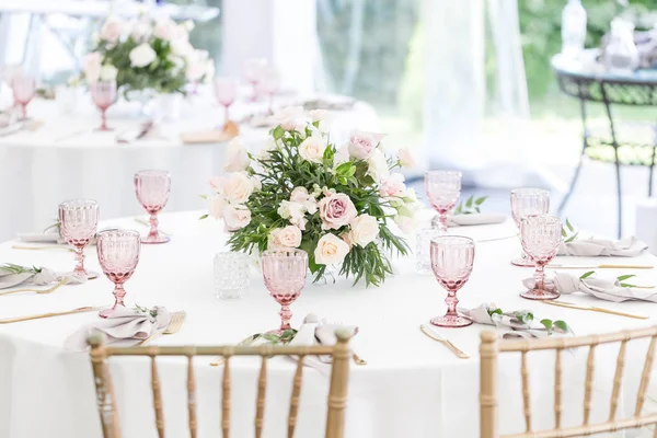 De instelling van het mooie tafel met servies en bloemen voor een feest, bruiloft receptie of een andere feestelijke gebeurtenis. Glaswerk en bestek voor catered gebeurtenis diner. — Stockfoto