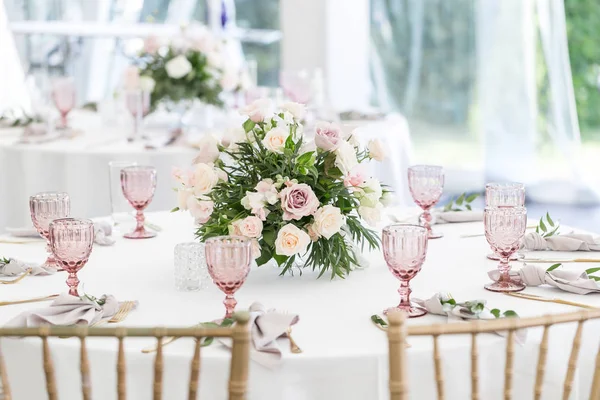 De instelling van het mooie tafel met servies en bloemen voor een feest, bruiloft receptie of een andere feestelijke gebeurtenis. Glaswerk en bestek voor catered gebeurtenis diner. — Stockfoto