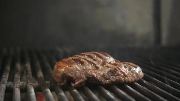 Fritar o bife no churrasco. Churrasco típico argentino ou asado. Queima de madeira na grelha e carvão quente vermelho . — Vídeo de Stock