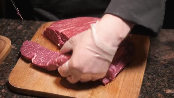 Шеф режет мясо на деревянной доске. Свежее сырое мясо в ресторане. Селективный фокус . — стоковое видео