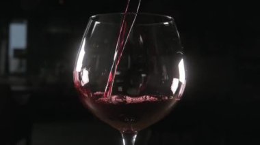 Barmen kırmızı şarap cam büyük şeffaf gemisinden dökülen