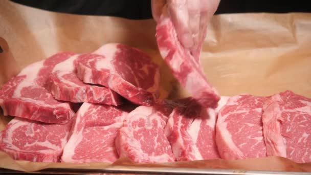 El chef corta carne. Carne fresca cruda sobre plato de metal sobre mesa oscura. Enfoque selectivo . — Vídeos de Stock