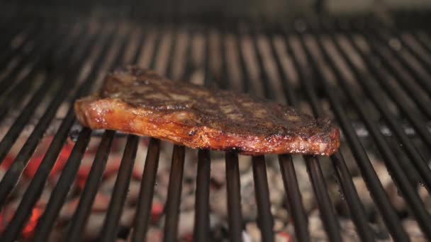 在烧烤上煎牛排。典型的阿根廷烧烤或 asado。在烧烤炉和红色的热煤中燃烧木材. — 图库视频影像