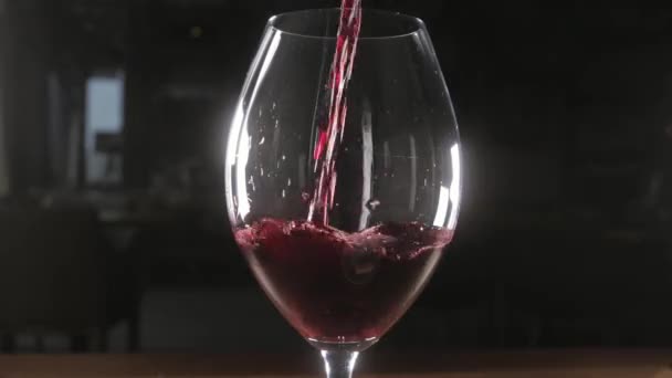 Cantinero vierte vino tinto en un vaso de gran recipiente transparente — Vídeos de Stock