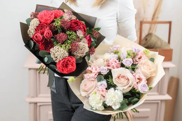 Hermoso ramo de lujo de flores mixtas en mano de mujer. el trabajo de la floristería en una florería. Una pequeña empresa familiar — Foto de Stock