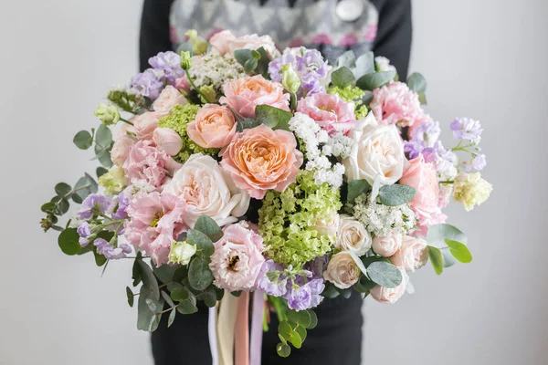 Hermoso ramo de lujo de flores mixtas en mano de mujer. el trabajo de la floristería en una florería. Una pequeña empresa familiar — Foto de Stock