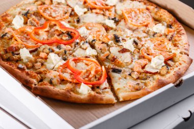 Pizza teslim kavramı kutu. Aç kutusuna sıcak lezzetli İtalyan dilimlenmiş pizza somon, yılan balığı, deniz ürünleri, zeytin, fesleğen, domates, mantar ile.