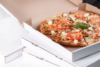 Pizza teslim kavramı kutu. Aç kutusuna sıcak lezzetli İtalyan dilimlenmiş pizza somon, yılan balığı, deniz ürünleri, zeytin, fesleğen, domates, mantar ile.