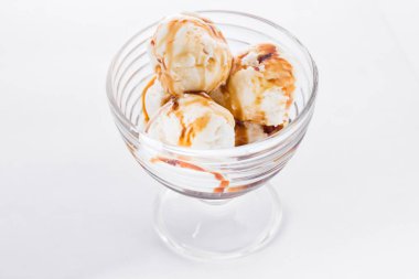 Vanilyalı dondurma ile beyaz zemin üzerine karamel şurup. Vanilyalı dondurma gözlük kase Kepçe.