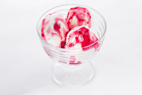 Vanilla ice cream with raspberry syrup on white background. Scoops of vanilla ice cream in glasses bowl.