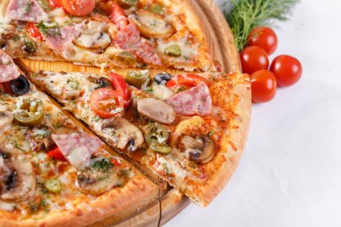 İtalyan mutfak ve pişirme kavramı. Lezzetli dilimlenmiş jambon, sosis, jalapenos, mantar, domates ile sıcak. Teslimat kavramı yemek.