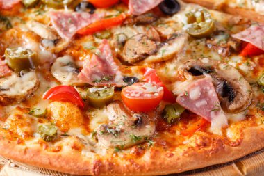 İtalyan mutfak ve pişirme kavramı. Lezzetli dilimlenmiş jambon, sosis, jalapenos, mantar, domates ile sıcak. Teslimat kavramı yemek.