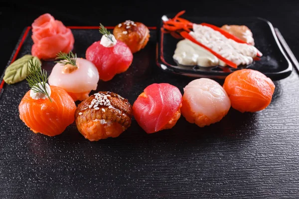 Japans eten, smakelijke maaltijd voor de lunch. Schaal-en schelpdieren. Sushi met paling, zalm, forel, tonijn zwarte achtergrond. — Stockfoto