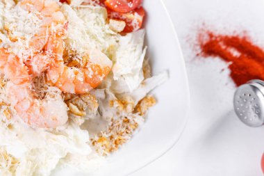 Sezar salata tavuk. Iceberg marul yaprağı ve parmesan peyniri ile giyinmiş kruton oluşmaktadır. Beyaz ışık arka plan