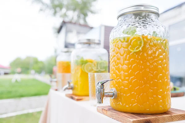 Glas Limonade mit aufgeschnittenen Zitrusfrüchten auf einem Buffettisch. Sommerfest im Freien. Entgiftung. — Stockfoto