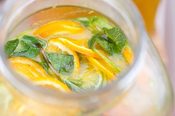 Glas bank lemonad med skivade citrusfrukter på ett buffébord. Sommarfest utomhus. Detox. — Stockfoto