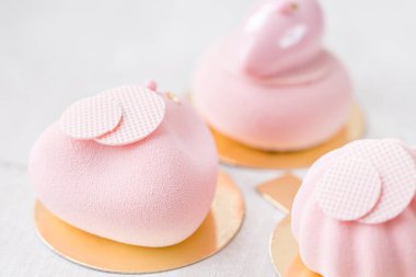 Üç pastel pembe pasta Beyaz ahşap masa üzerinde. Küçük tatlı çay veya kahve ile servis. duvar kağıdı, yatay fotoğraf