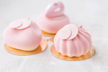 Üç pastel pembe pasta Beyaz ahşap masa üzerinde. Küçük tatlı çay veya kahve ile servis. duvar kağıdı, yatay fotoğraf