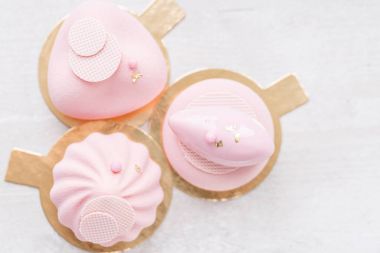 Üç pastel pembe pasta Beyaz ahşap masa üzerinde. Küçük tatlı çay veya kahve ile servis. duvar kağıdı, yatay fotoğraf