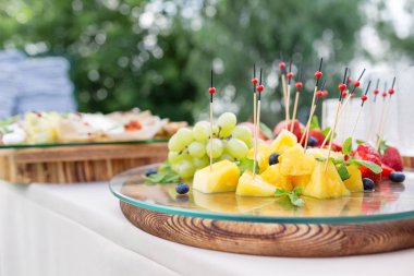 Ahşap plaka ile dilimlenmiş meyve ve çilek bir büfe tablo. Yaz Partisi açık. Yatay fotoğraf