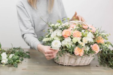 yakın çekim yakışıklı kadın çiçekçi. Çiçek atölye - kadın güzel çiçek kompozisyon bir buket bir hasır sepet yapım. Floristik kavramı