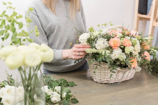 Γκρο πλαν χέρια θηλυκό ανθοπωλείο. Floral εργαστήριο - γυναίκα κάνοντας μια σύνθεση όμορφο λουλούδι μια ανθοδέσμη σε ένα ψάθινο καλάθι. Ανθοπωλεία έννοια — Φωτογραφία Αρχείου