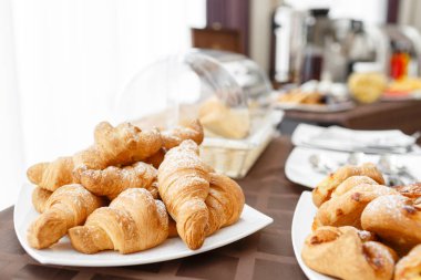 Taze kruvasanlar beyaz tabakta. Fransız geleneksel hamur işi. Otel açık büfe Servis Kahvaltı.