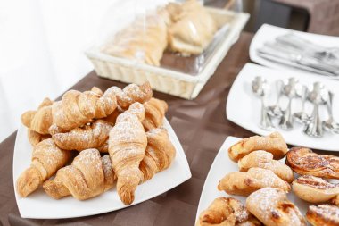 Taze kruvasanlar beyaz tabakta. Fransız geleneksel hamur işi. Otel açık büfe Servis Kahvaltı.