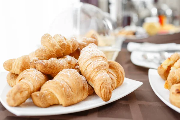 Croissants frescos en plato blanco. Pastelería tradicional francesa. Desayuno en el hotel smorgasbord . — Foto de Stock