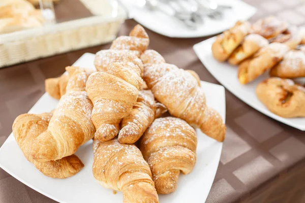 Färska croissanter på vit platta. Franska traditionella bakverk. Frukost i hotel smörgåsbord. — Stockfoto