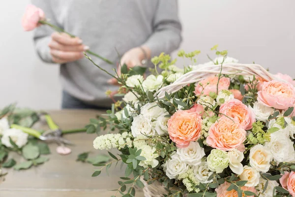 Primer plano manos florista femenina. El taller floral - la mujer que hace la composición hermosa de flores el ramo en la cesta de mimbre. Concepto floristería — Foto de Stock