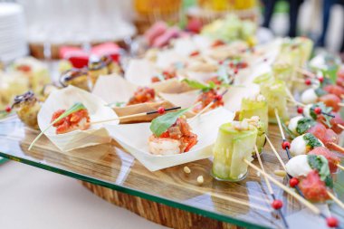 Lezzetli karides ve dilimlenmiş domates ahşap bir tekne. Kabak çam fıstığı ile alır. Lezzetli büfe masa. Yaz Partisi açık. Kavram catering