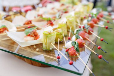 Kabak çam fıstığı ile alır. Kiraz domates, mozzarella ve fesleğen şiş üzerinde. . Pesto sos. Lezzetli büfe masa. Yaz Partisi açık.